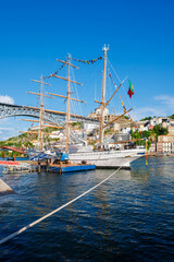 View of Vila Nova de Gaia city with a sailing ship and Dom Luis I bridge over Douro river. Porto,...