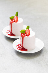 Strawberry Panna Cotta of cylindrical shape with strawberry sauce. On a plate. 