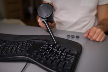 Clean keyboard with vacuum for office maintenance, improving hygiene and professionalism
