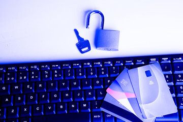 Online shopping security concept, credit cards on a computer keyboard and a padlock with a key.