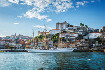 View of Porto city and Douro river with sailing ship from famous tourist viewpoint Marginal de Gaia riverfront. Porto, Vila Nova de Gaia, Portugal