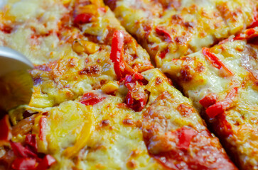 Cutting famous Neapolitan pizza based on buffalo mozzarella and tomatoes with a pizza cutter