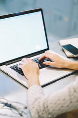 Professional web designer using application on netbook with mock up screen for  creating project, back view of female manager making online research browsing web page on laptop computer in office