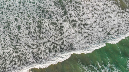 Aerial view of gentle waves along the beautiful shoreline