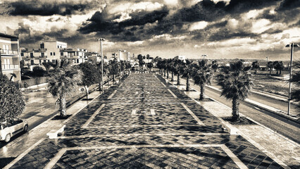 Obraz premium Aerial view of city promenade along the ocean, beautiful coast at sunset from drone.