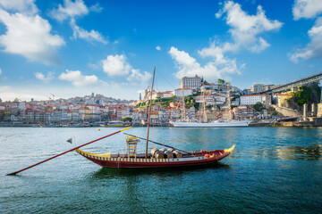 View of Porto city and Douro river with traditional boats with port wine barrels and sailing ship...