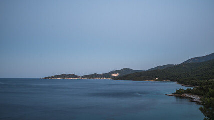 Fototapeta premium Distant view of the town of Limenas and the marble mine on the island of Thassos in the evening