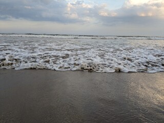 The image shows a beach scene with waves crashing onto the shore.