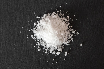 Pile of sea salt on a black natural background.