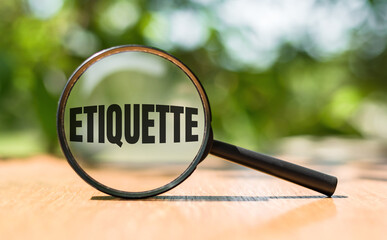 Close-Up View of a Magnifying Glass Focusing on the Word Etiquette on a Bright Day