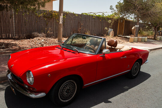 Mitzpe Ramon, Israel- May 10,2024: Fiat 124 Sport Spider red antique collector convertible car parked on side road