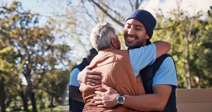 Happy, people and volunteers with hug for celebration of giving with boxes outdoor in nature at park. Excited, group of friends and community service with love embrace for ngo, donation and hope