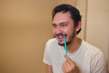 A man with blue teeth looks amused in a closeup shot, with a spontaneous and vibrant expression...