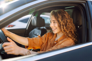Relaxed woman enjoys drive while sitting in a car. Car travel concept. Lifestyle.