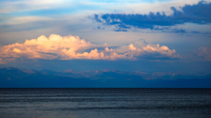 A vast expanse of water with towering mountains in the distance