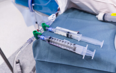 medical syringes with anesthetic drugs - propofol, midazolam, fentanyl - arranged on sterile tray in hospital setting