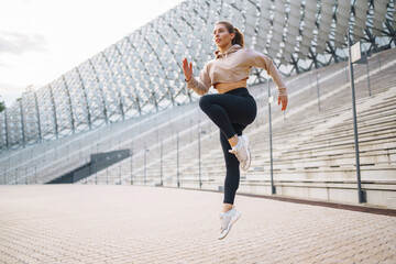 Young woman wearing sports clothes warming up before jogging on the street. People, sport, fitness...