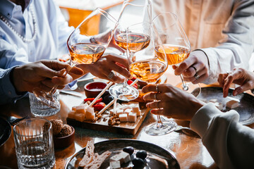 Friends having a dinner party with different kinds of appetizers and rose wine.