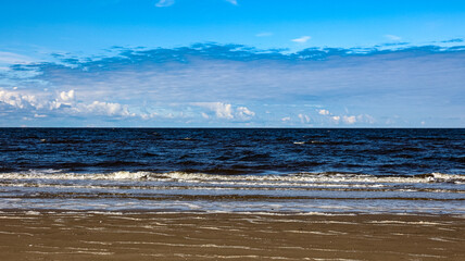 There is a vast expanse of water under a clear blue sky in the backdrop