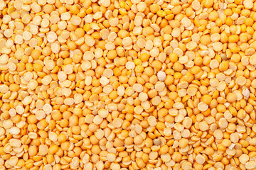 Uncooked, split, yellow peas background. Dry peas grains. Top view