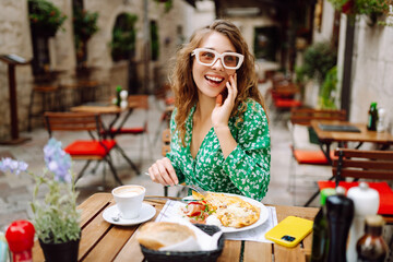 Woman eating italian pasta and drinking coffee at restaurant on the street in Rome. Concept of...