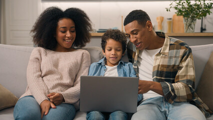 Happy African American family laughing woman mom female cheerful dad man male little boy son child...