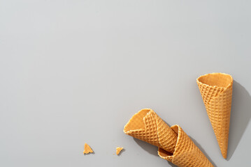 A broken ice cream cone on gray surface with keywords related to food and baked goods
