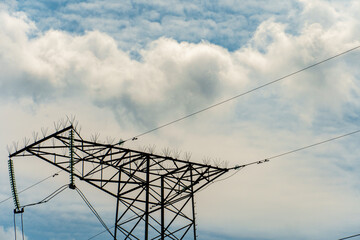 Power lines and high-voltage wires against a background of blue sky and fluffy clouds. Energy infrastructure of Ukraine.