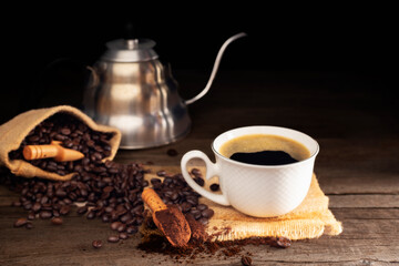 Black coffee with white cup and roasted coffee beans brown sugar and a cup of hot espresso coffee flat top view on a dark background