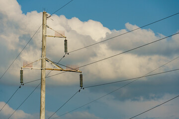 Power lines and high-voltage wires against a background of blue sky and fluffy clouds. Energy infrastructure of Ukraine.