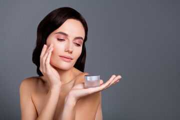 Photo of brunette hair girl hold balm jar touch face applying isolated grey color background