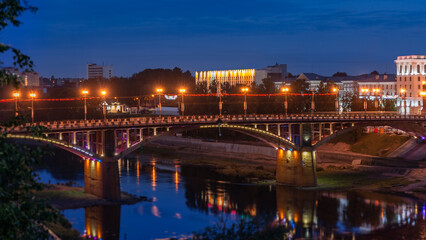 Twilight cityscape with illuminated bridge over river