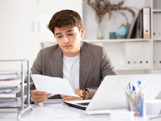 Businessman works in the office - puts documents in order and draws up a contract