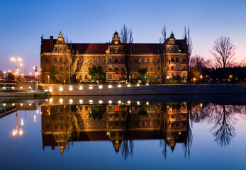 Historic building reflected in water at twilight