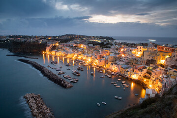 Twilight over coastal town with illuminated harbor
