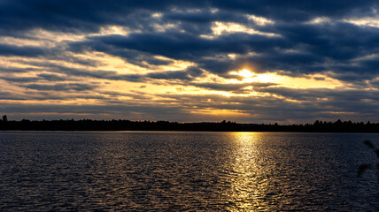 The sun sets over a vast expanse of water, creating a beautiful scene