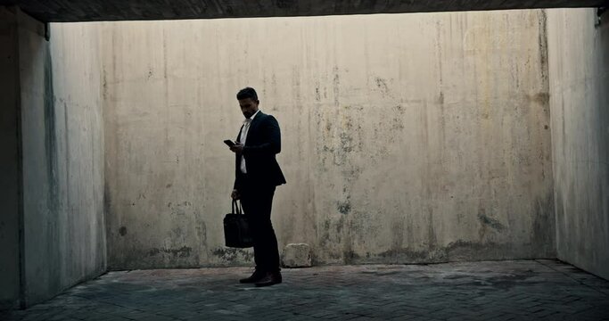 Businessman, rat race and walking with phone isolated in messy room for dead end job or no opportunity in studio. Male person or worker and stuck, trapped or blocked from progress or career promotion