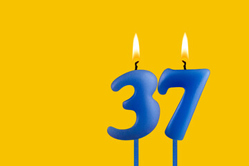 Blue candle number 37 - Birthday on yellow background