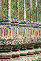 Colorful intricate decor on gold painted Thai temple pillars