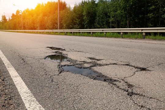 Potholes on bad asphalt road. Closeup
