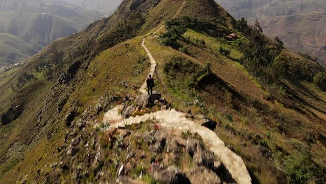 Un hombre joven caminando por las monta&ntilde;as.silueta de turista con mochila ,Viaje estilo de vida saludable excursi&oacute;n en solitario vacaciones activas al aire libre, Amplio panorama de monta&ntilde;a,Drone