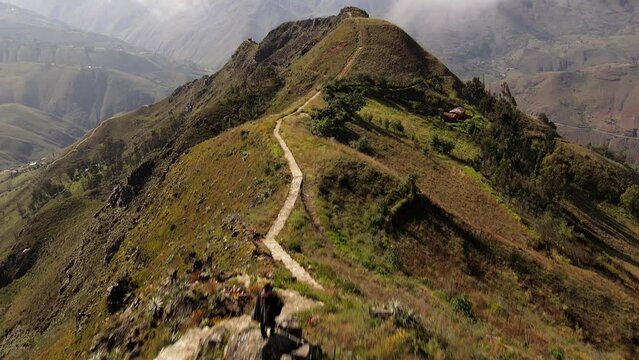 Un hombre joven caminando por las monta&ntilde;as.silueta de turista con mochila ,Viaje estilo de vida saludable excursi&oacute;n en solitario vacaciones activas al aire libre, Amplio panorama de monta&ntilde;a,Drone