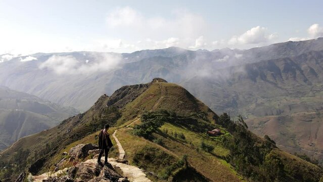 Un hombre joven caminando por las monta&ntilde;as.silueta de turista con mochila ,Viaje estilo de vida saludable excursi&oacute;n en solitario vacaciones activas al aire libre, Amplio panorama de monta&ntilde;a,Drone