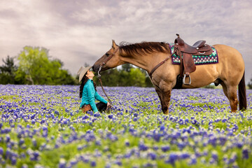 Texas Cowgirl in Bluebonnet wildflower field with horse western fashion