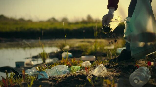 A man sorts plastic waste, collecting garbage into bags for subsequent disposal and recycling. This supports sustainable recycling of materials, allowing them to be reused. Clean planet concept