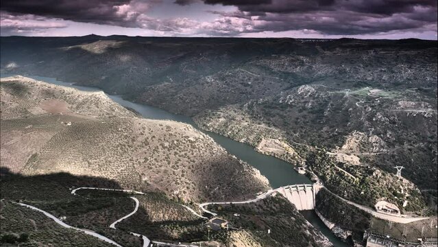 Time lapse of clouds moving over mountain and Douro river with spanish Saucelle Dam. Border between Portugal and Spain. National Parks. View from portuguese Penedo Durao lookout.