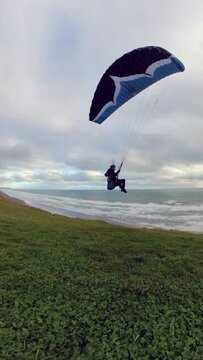 High-speed paragliding flight along the coast of New Zealand. Adventure, freedom, and aerial landscape concept.