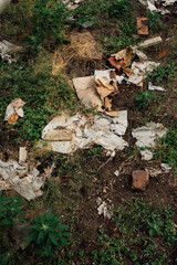 garbage mess in public garden, p-patch with cardboard, paper, bricks