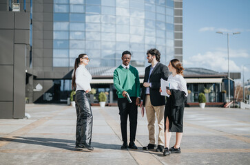 Diverse group of business professionals engaged in a discussion on corporate strategy and market expansion, standing outside an office building.