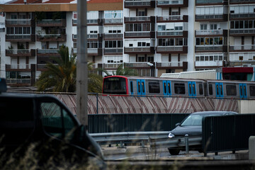 Train moving above cars near apartments